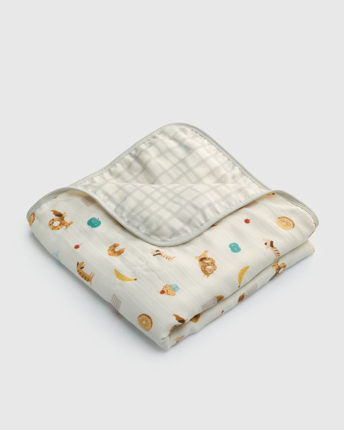 Folded baby blanket with animal prints on a light gray background