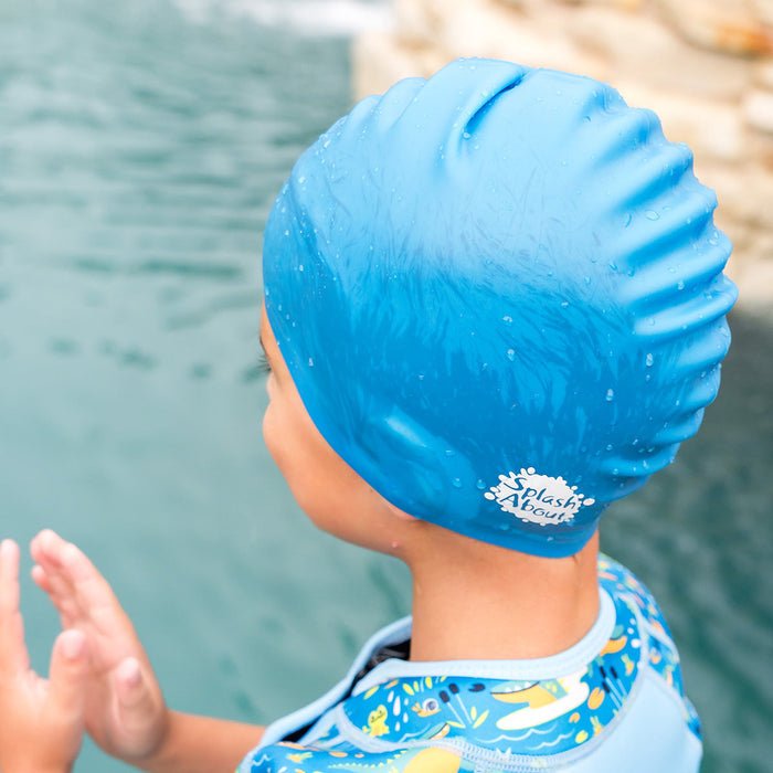 Close-up of kid wearing blue silicone swim cap, back.
