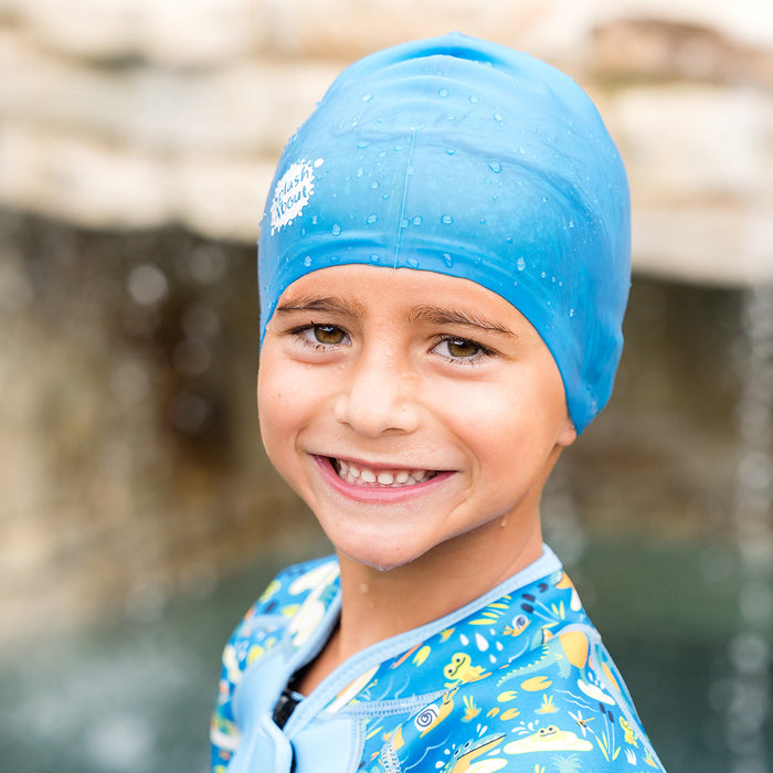 Close-up of kid wearing blue silicone swim cap, front.