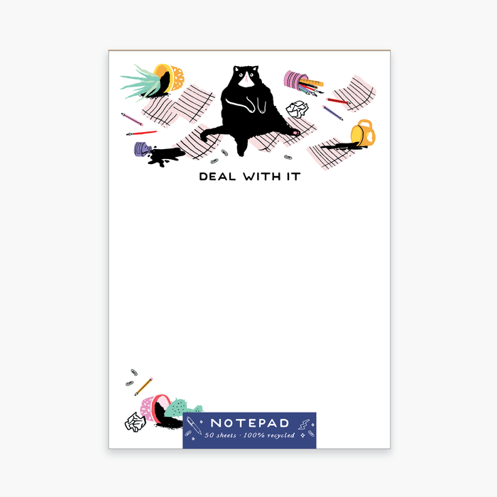 A colorful notepad with a cartoon image of a black cat and various playful illustrations such as a pencil, paper, and scissors. The text on the cover says 'DEAL WITH IT'.