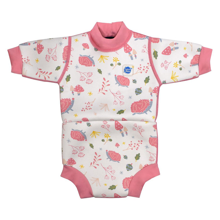 Baby wetsuit with built in swim diaper in white with pink trims and forest themed print, including hedgehogs, mushrooms and leaves. Front.