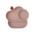 A silicone baby plate in a dusty rose pink color, featuring three compartments and a small red apple-shaped accent on the top left edge, shown against a plain white background.