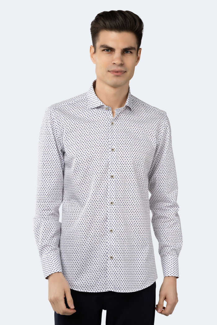 A male model wearing a white jacquard shirt with tiny navy petals and gold dots pattern, featuring a button-down front and long sleeves.