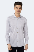 A male model wearing a white jacquard shirt with tiny navy petals and gold dots pattern, featuring a button-down front and long sleeves.