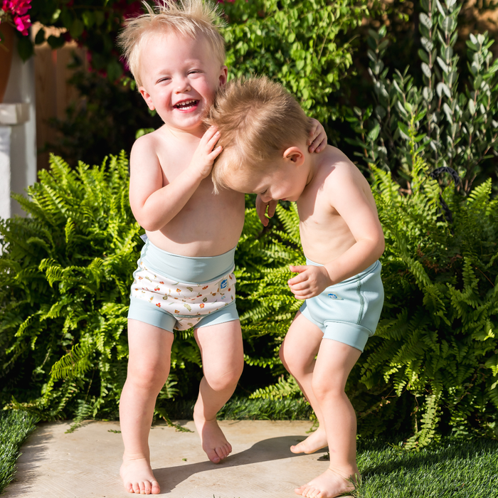 Children wearing reusable swim diaper in pistachio. Front