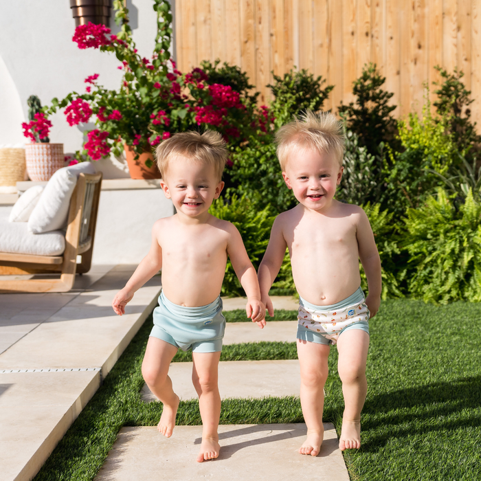 Children wearing reusable swim diaper in pistachio. Front