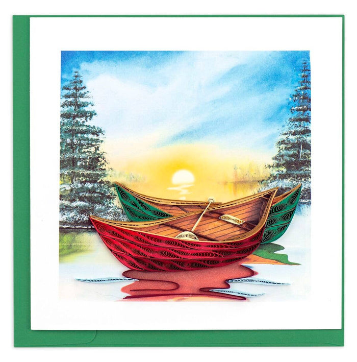 A handcrafted greeting card with a quilled design depicting two red and green river canoes on a body of water, with a blue sky and sun in the background.