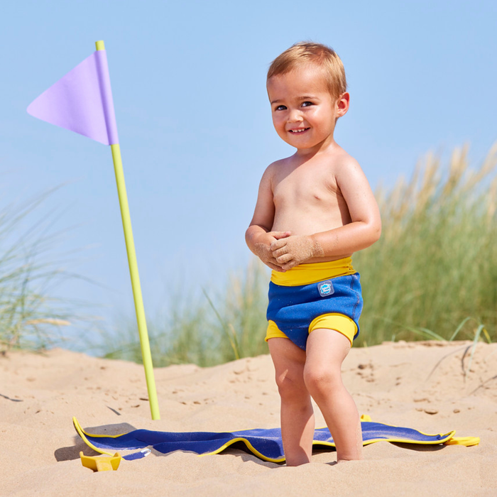 Child on neoprene mat at the beach