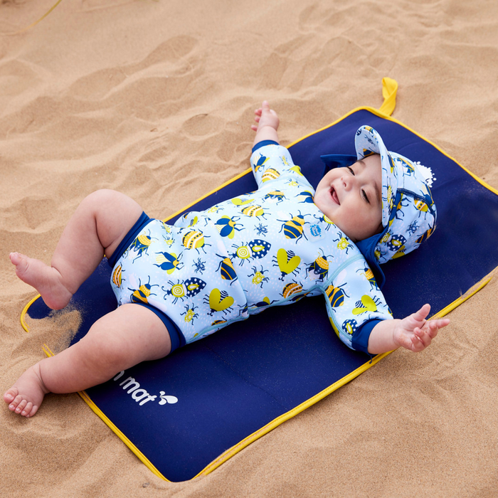 Child on neoprene mat at the beach