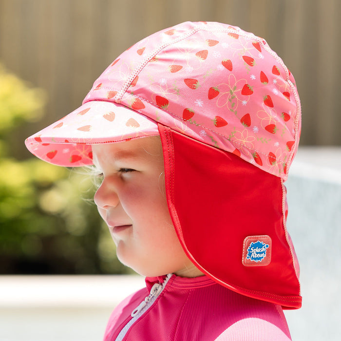Little one wearing legionnaire style sun hat in pink and red, with strawberries themed print panel.