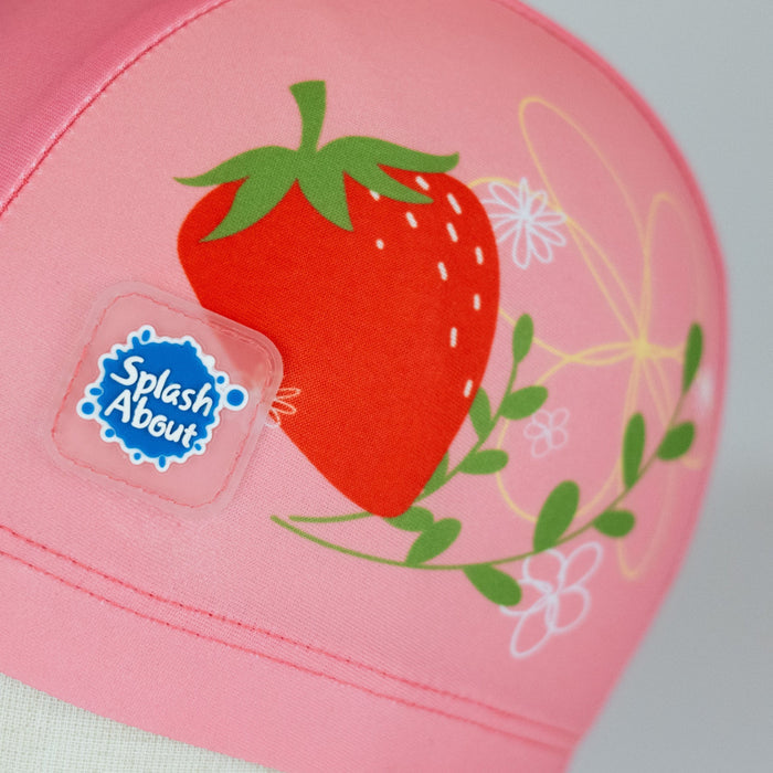 Baby swim hat in pink featuring strawberries themed print.
