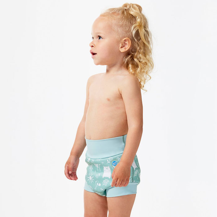 Lifestyle image of little one wearing swim nappy, standing up, side.