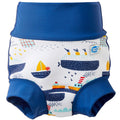 Reusable swim nappy in white with navy blue ribs and boats themed print. Front.