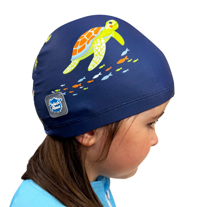 Child wearing baby swim hat in navy featuring turtles themed print.
